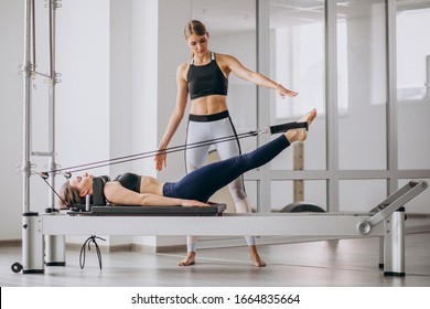Woman with pilates trainer practising pilates