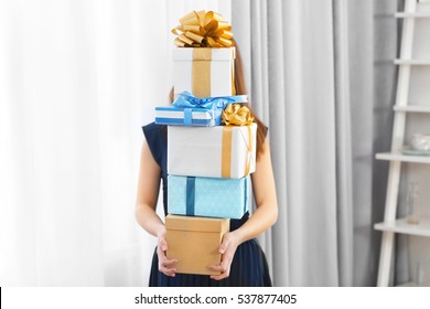 Woman With Pile Of Presents At Home