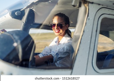 Woman Pilot Sitting in Cabin of Modern Aircraft.