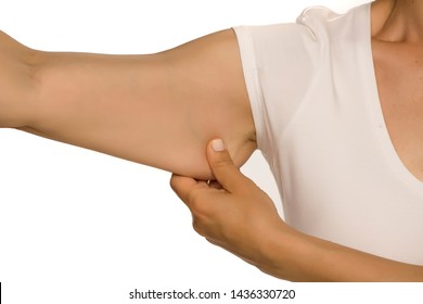 Woman pinching a fat on her arm on white background