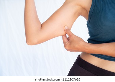 Woman pinching a fat on her arms. Authentic skin tan asian Thailand. Saggy muscle and excess fat. close up slim fit body woman. shapely girl and good health concept. - Shutterstock ID 2111107616
