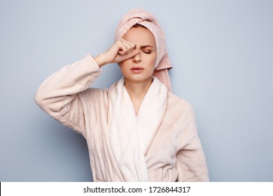 Woman In Pink Bathrobe With Towel On Head, After Shower At Morning, Sleepy And Tired, Wants To Sleep, Rubbing Her Eyes. Night Owl Type, Wake Up Early Concept