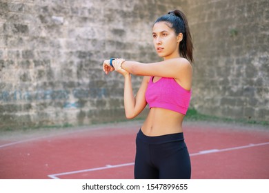 Woman with pink bra stretching in basketball yard - Powered by Shutterstock