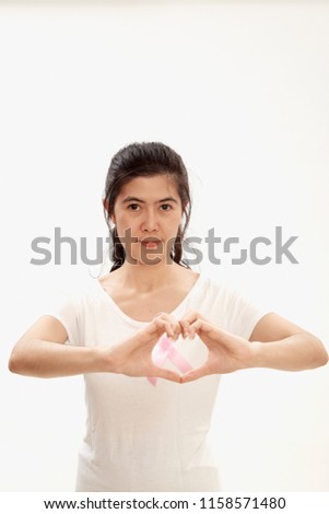 woman with pink cancer ribbon doing heart shape with her hands on white background, Medicine and breast cancer concept