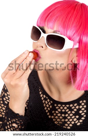 woman with pink hair eating raw vegetable