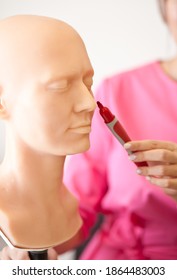 Woman In A Pink Medical Uniform Shows With Marker On A Human Head Anatomy Model. Education, Anthropology,science, Anatomy Concept.