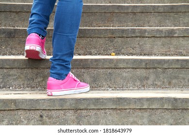 Woman in pink / purple canvas vintage shoes and blue jeans.