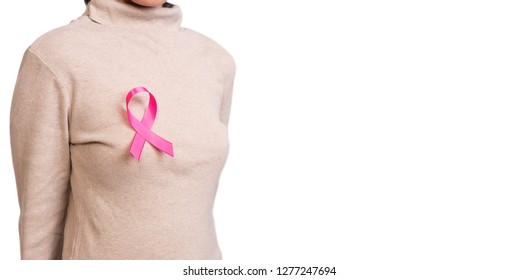 Woman with pink ribbon on chest. supporting symbol of breast cancer awareness and international women day campaign. - Shutterstock ID 1277247694