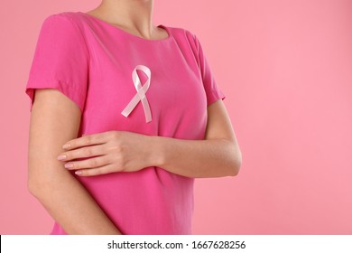 Woman with pink ribbon on color background, closeup. Breast cancer awareness - Shutterstock ID 1667628256