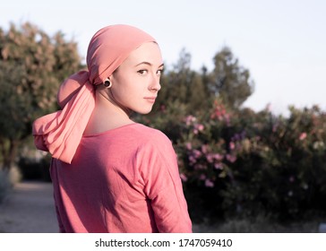 Woman with pink scarf on her head. Cancer awareness - Powered by Shutterstock