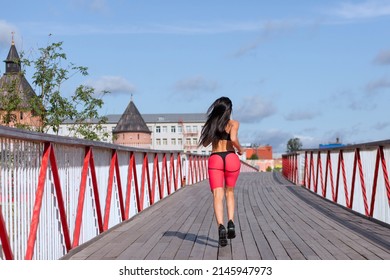 A Woman In A Pink Sweat Suit Runs Across The Bridge.