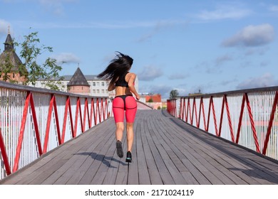 A Woman In A Pink Sweat Suit Runs Across The Bridge.