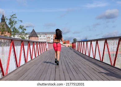 A Woman In A Pink Sweat Suit Runs Across The Bridge.