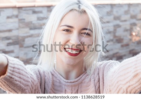 Frau in rosa Pullover macht Selfie