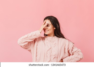 Woman In Pink Sweater Posing On Isolated Background. Funny Girl With Smile Makes Facepalm