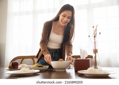 Woman place the curry cup, set the food on the table. - Powered by Shutterstock