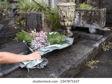 woman placing flowers in the cemetery