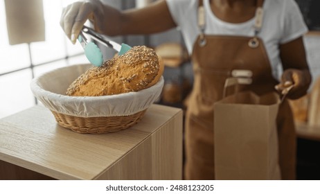 Woman placing freshly baked bread into a paper bag at a bakery using tongs, wearing an apron, inside a cozy shop setting. - Powered by Shutterstock