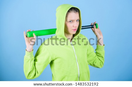 Woman play baseball game or going to beat someone. Baseball female player concept. She is dangerous. Girl hooded jacket hold baseball bat blue background. Brutal and bully. Woman in baseball sport.