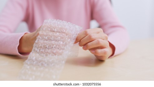 Woman play with bubble wrap to relief stress 