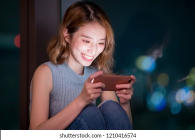 Woman Play Mobile Game Happily Indoor At Night