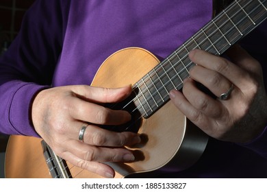 Woman playing a 5 string tenor ukulele, midsection, selective focus  - Shutterstock ID 1885133827