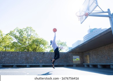 A Woman Playing Basketball In The Park