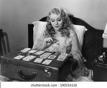 Woman Playing Cards In Bed