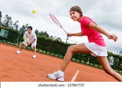 Woman playing doubles in tennis at a clay court