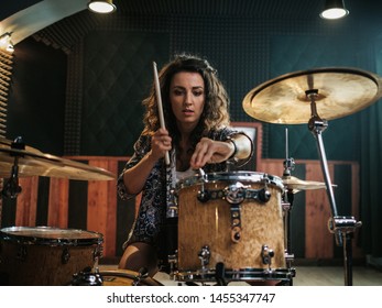 Woman playing drums during music band rehearsal - Shutterstock ID 1455347747