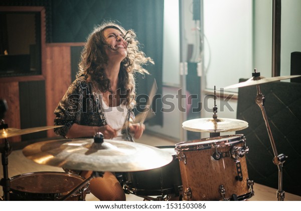 Woman playing\
drums during music band\
rehearsal
