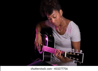 Woman Playing Guitar On A Black Background