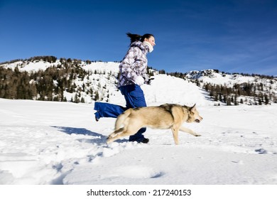Woman playing with her dog on snowy landscape