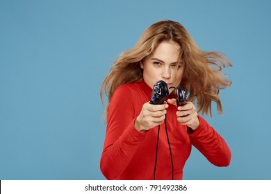  Woman Playing Joysticks In Playstation On A Blue Background                              