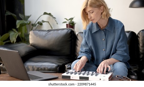 Woman Playing On Midi Controller In Living Room With Couch, Producer Of Music With Laptop On Table. Music Producer At Home Studio With Professional Equipment. 