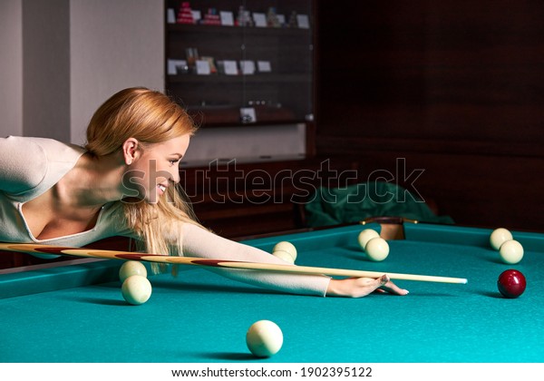 Девушка играет в бильярд