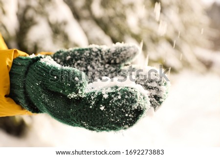 Woman playing with snow outdoors, closeup. Winter vacation