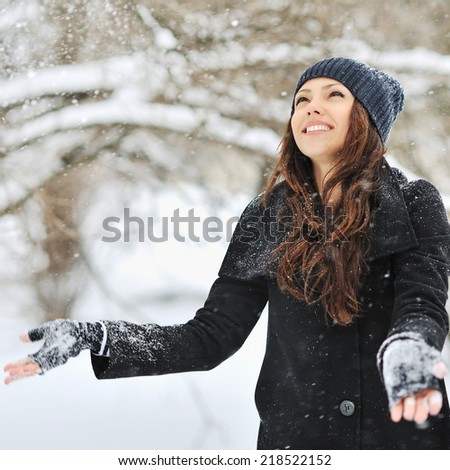 Woman playing with snow in a winter park 