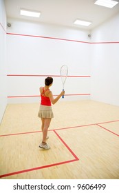 woman playing squash in the squash court