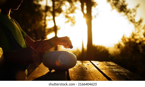 Woman Playing Steel Tongue Drum At Sunset