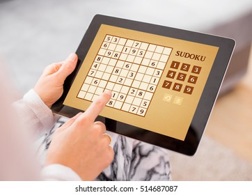Woman playing Sudoku on tablet computer