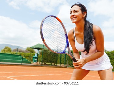 Woman playing tennis and waiting for the service