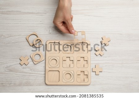 Woman playing tic tac toe game at white wooden table, top view Stock photo © 