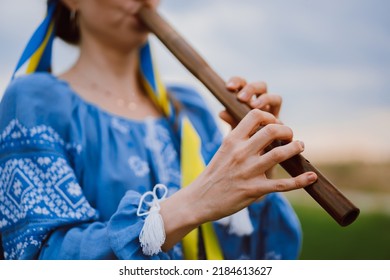 Woman Playing Woodwind Wooden Flute - Ukrainian Sopilka Outdoors. Folk Music, Culture Concept. Musical Instrument. Lady In Traditional Embroidered Shirt - Blue Vyshyvanka.