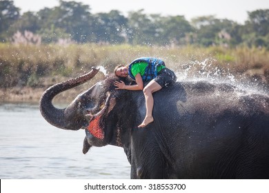Woman plays with elephant in river