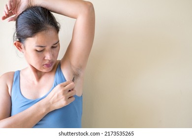 Woman plucking armpit underarm with tweezers. Hygiene skin body care and beauty. Healthcare and medicine concept.
