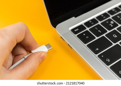 Woman plugging charger in a laptop. Type C charging port. Low battery concept
