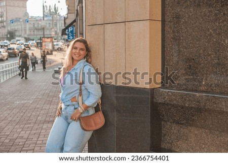 A woman of plus size, American or European appearance walks in the city enjoying life. A young lady with excess weight, stylishly dressed in the center of the city. Natural beauty