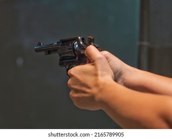 Woman Pointing Gun At Target On Dark Background, Front Gun Focus, Vintage Tone