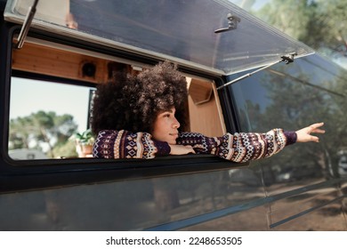 Woman pointing with her arm out the window of her van